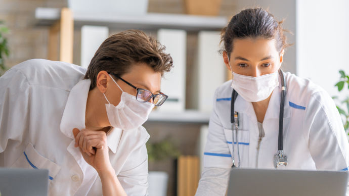 Arzt unterhält sich mit Kollegin über der Verlauf der IgA-Nephropathie