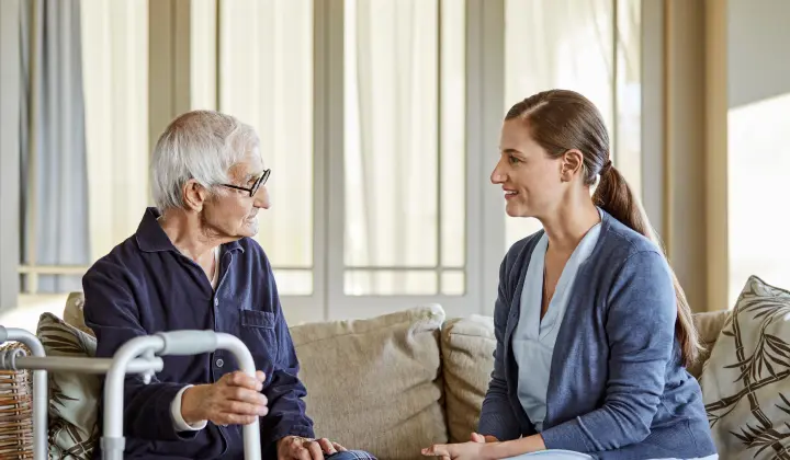Mann mit Parkinson im Gespräch mit Parkinson-Assistentin